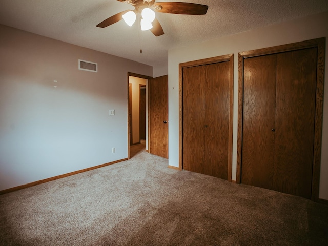 610 25th St SW, Austin, MN 55912 - unfurnished bedroom with carpet floors, two closets, a ceiling fan, and a textured ceiling
