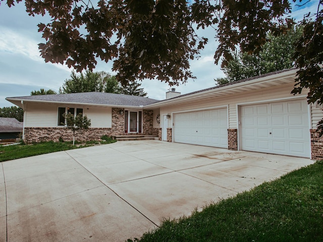 610 25th St SW, Austin, MN 55912 - single story home featuring brick siding, driveway, a chimney, and a garage
