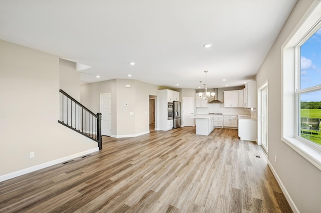 2627 Arbor Dr, Buffalo, MN 55313 - unfurnished living room with a chandelier, light wood-type flooring, stairs, and recessed lighting