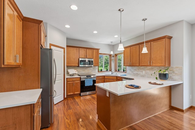13725 Maxwell Rd, Chisago Lake Twp, MN 55013 - kitchen featuring stainless steel appliances, a peninsula, wood finished floors, decorative backsplash, and recessed lighting
