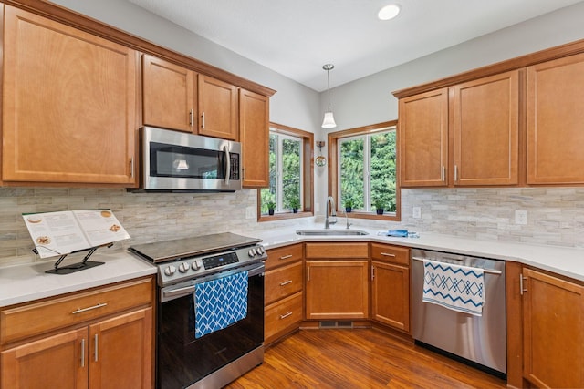 13725 Maxwell Rd, Chisago Lake Twp, MN 55013 - kitchen featuring appliances with stainless steel finishes, dark wood-style floors, tasteful backsplash, light countertops, and pendant lighting