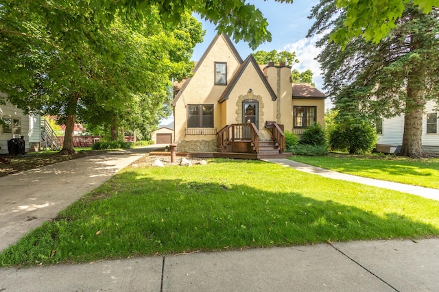 210 1st Ave SW, Glenwood, MN 56334 - tudor home with stucco siding, a front lawn, a chimney, and a garage