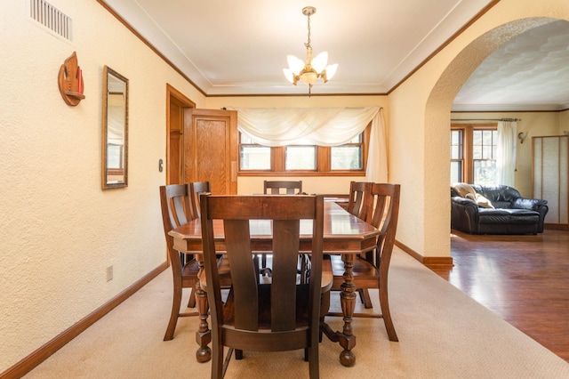 210 1st Ave SW, Glenwood, MN 56334 - dining space with arched walkways, a chandelier, a textured wall, and crown molding