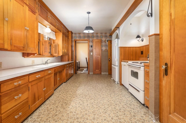 210 1st Ave SW, Glenwood, MN 56334 - kitchen featuring white appliances, brown cabinets, light countertops, a wainscoted wall, and decorative light fixtures
