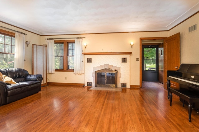 210 1st Ave SW, Glenwood, MN 56334 - living room with wood finished floors, a brick fireplace, and ornamental molding