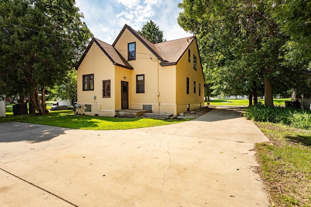210 1st Ave SW, Glenwood, MN 56334 - view of front of property featuring concrete driveway, stucco siding, a front lawn, and a shingled roof