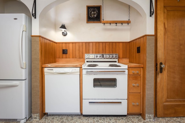 210 1st Ave SW, Glenwood, MN 56334 - kitchen with white appliances, a wainscoted wall, light countertops, wooden walls, and brown cabinetry