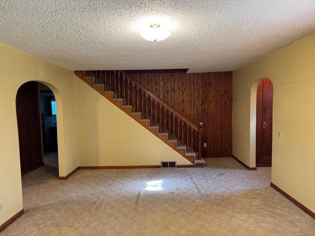 20247 410th Ave, Mickinock Twp, MN 56751 - finished basement featuring arched walkways, carpet flooring, stairs, a textured ceiling, and wooden walls