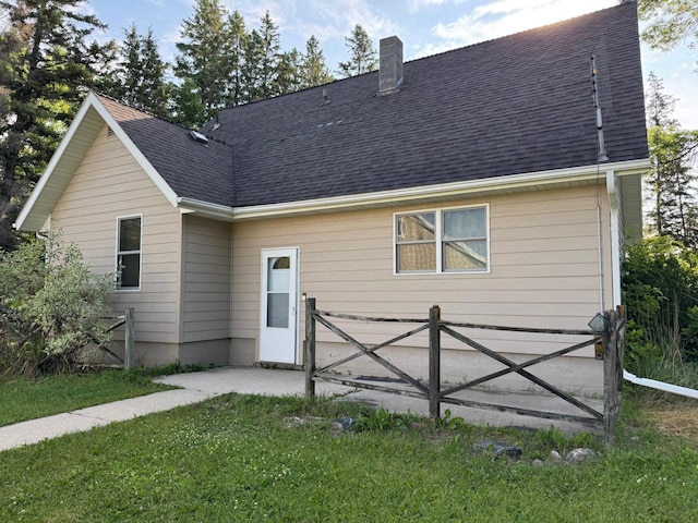 20247 410th Ave, Mickinock Twp, MN 56751 - rear view of property featuring a shingled roof, a chimney, and a yard