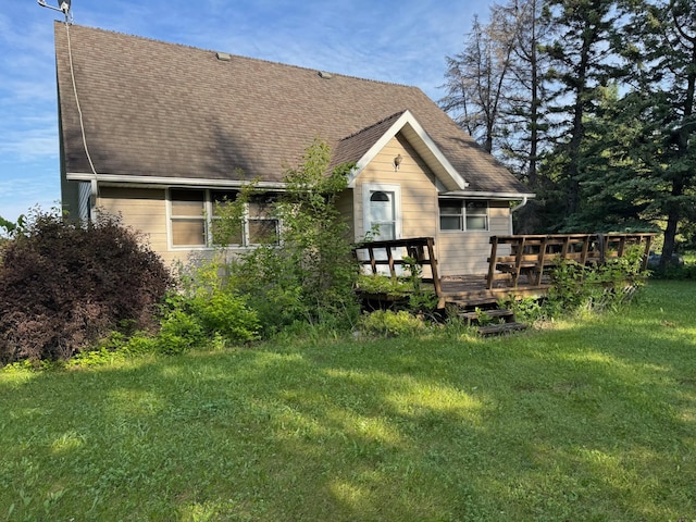 20247 410th Ave, Mickinock Twp, MN 56751 - rear view of house with a wooden deck, a lawn, and roof with shingles