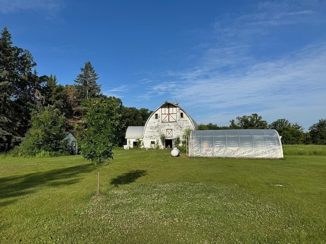 20247 410th Ave, Mickinock Twp, MN 56751 - view of green lawn featuring an outdoor structure, a barn, and a greenhouse