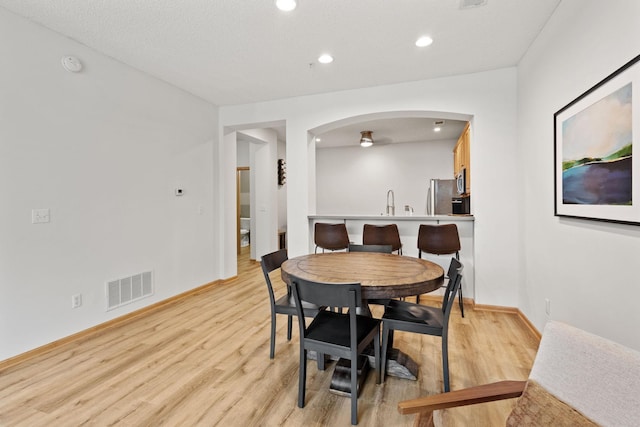 8479 Forestview Ln N, Maple Grove, MN 55369 - dining space with light wood-style floors, arched walkways, and recessed lighting