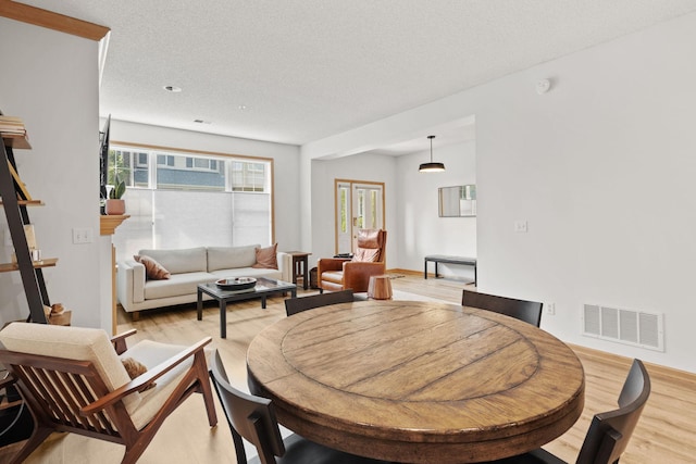 8479 Forestview Ln N, Maple Grove, MN 55369 - dining space featuring light wood-style floors, healthy amount of natural light, and a textured ceiling