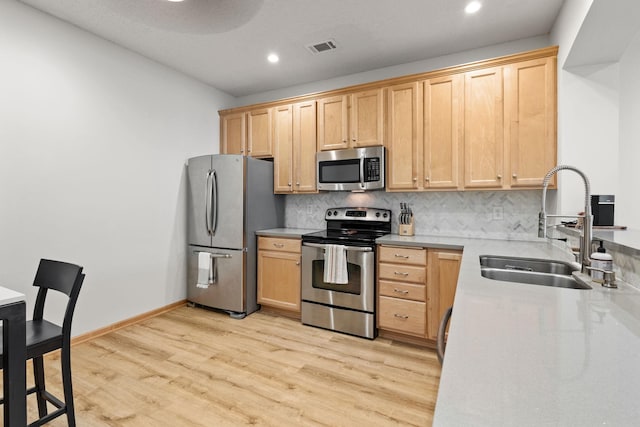 8479 Forestview Ln N, Maple Grove, MN 55369 - kitchen with appliances with stainless steel finishes, tasteful backsplash, recessed lighting, light wood-style flooring, and light countertops