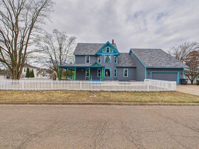 905 3rd Ave SW, Pine City, MN 55063 - victorian-style house featuring a chimney, a garage, a fenced front yard, concrete driveway, and a porch