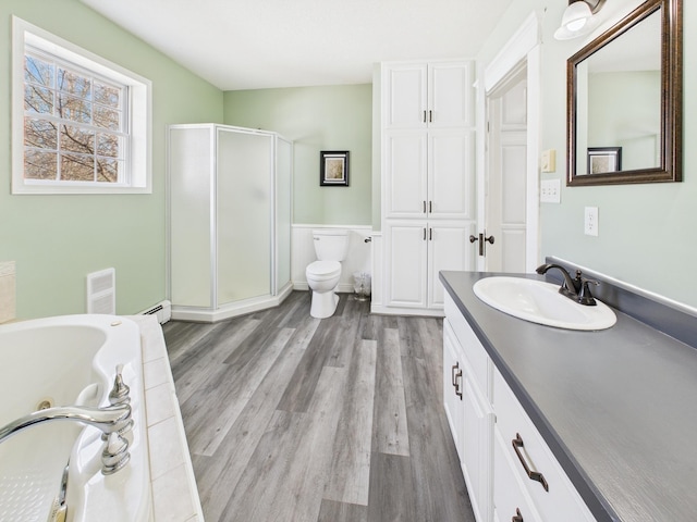905 3rd Ave SW, Pine City, MN 55063 - full bath with a shower stall, vanity, a baseboard radiator, a whirlpool tub, and wood finished floors