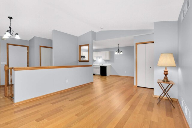 1110 Lilac Ct, Waconia, MN 55387 - unfurnished living room featuring a chandelier, light wood finished floors, and lofted ceiling