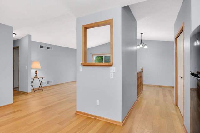 1110 Lilac Ct, Waconia, MN 55387 - hall with light wood finished floors, a chandelier, and lofted ceiling