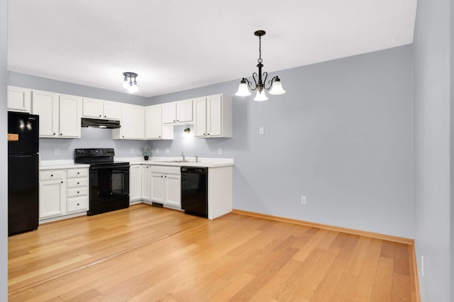 1110 Lilac Ct, Waconia, MN 55387 - kitchen featuring black appliances, under cabinet range hood, a chandelier, light countertops, and white cabinets