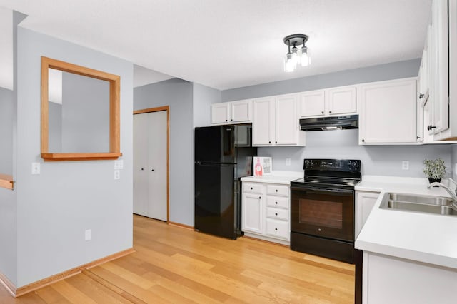 1110 Lilac Ct, Waconia, MN 55387 - kitchen with black appliances, under cabinet range hood, light wood-style flooring, white cabinets, and light countertops