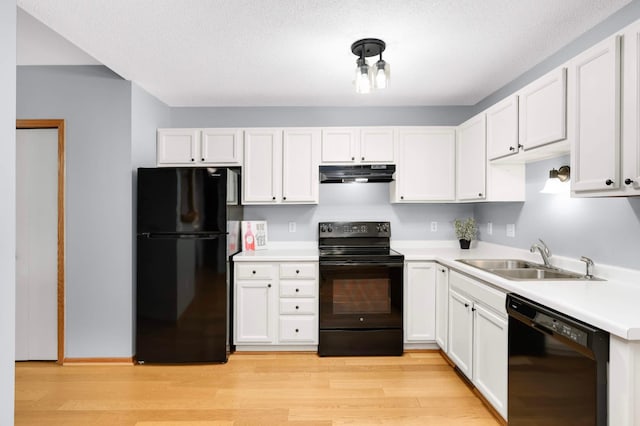 1110 Lilac Ct, Waconia, MN 55387 - kitchen featuring black appliances, under cabinet range hood, white cabinetry, and light wood-type flooring