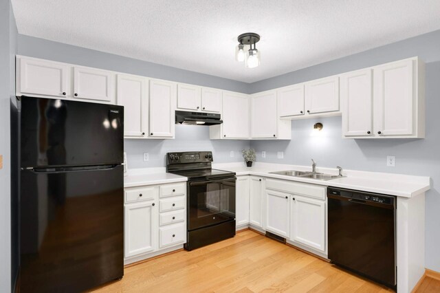 1110 Lilac Ct, Waconia, MN 55387 - kitchen featuring black appliances, under cabinet range hood, light wood-style flooring, and white cabinetry