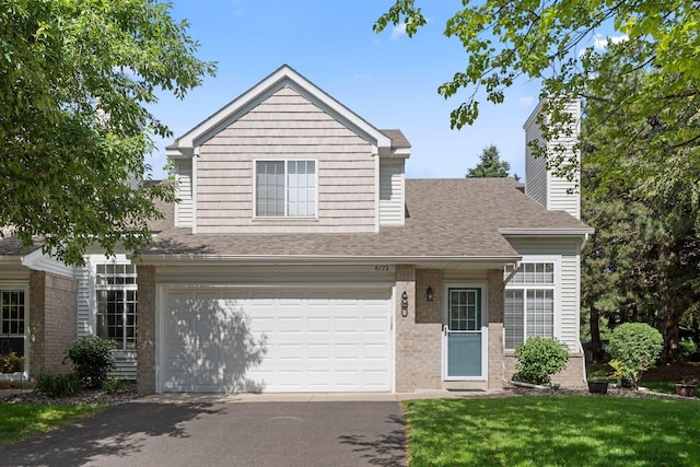 8772 Benson Way Unit 81, Inver Grove Heights, MN 55076 - traditional-style house with asphalt driveway, roof with shingles, an attached garage, brick siding, and a front lawn