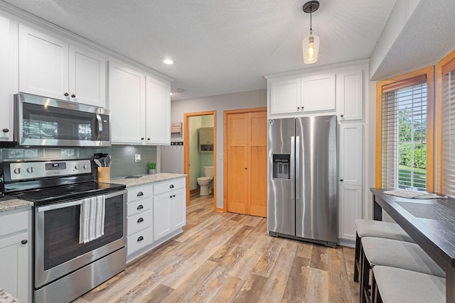 8772 Benson Way Unit 81, Inver Grove Heights, MN 55076 - kitchen featuring stainless steel appliances, light wood-style floors, white cabinetry, decorative backsplash, and recessed lighting