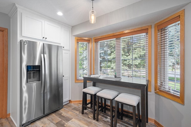 8772 Benson Way Unit 81, Inver Grove Heights, MN 55076 - kitchen with stainless steel fridge, light wood-style flooring, white cabinets, plenty of natural light, and recessed lighting