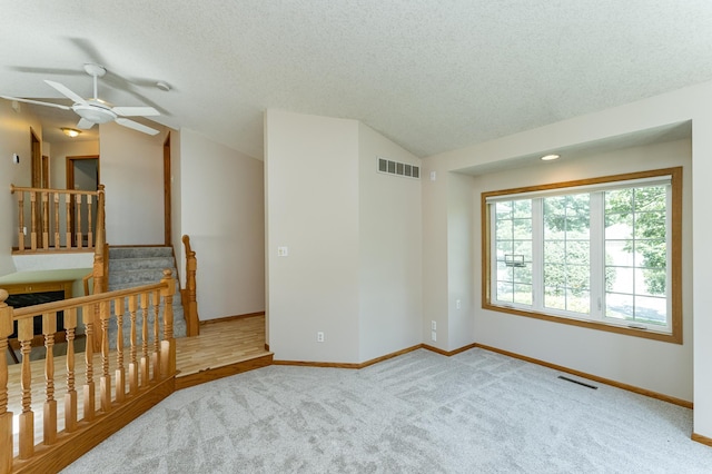 816 Bristol Ln NE, Rochester, MN 55906 - spare room with ceiling fan, lofted ceiling, carpet flooring, and a textured ceiling