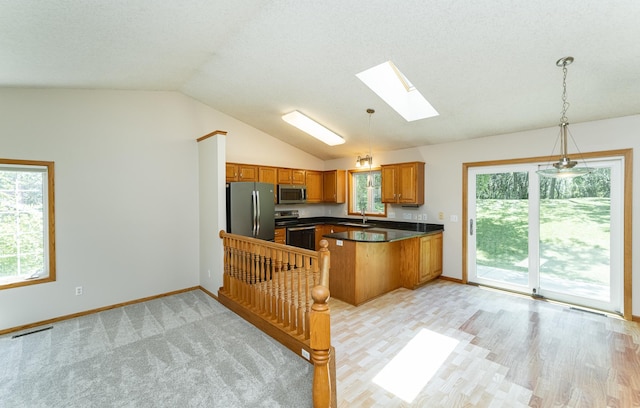 816 Bristol Ln NE, Rochester, MN 55906 - kitchen featuring stainless steel appliances, a skylight, dark countertops, brown cabinetry, and vaulted ceiling