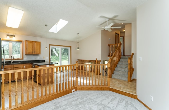 816 Bristol Ln NE, Rochester, MN 55906 - kitchen featuring dark countertops, lofted ceiling, a skylight, hanging light fixtures, and a peninsula