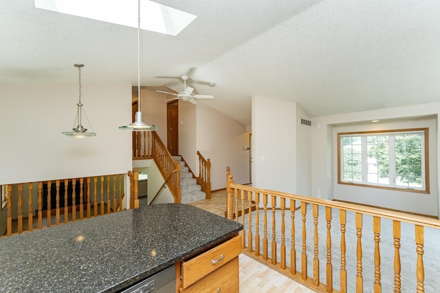 816 Bristol Ln NE, Rochester, MN 55906 - kitchen with light wood-style floors, a skylight, vaulted ceiling, a ceiling fan, and decorative light fixtures