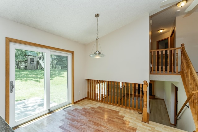 816 Bristol Ln NE, Rochester, MN 55906 - unfurnished dining area featuring light wood-style floors, vaulted ceiling, a textured ceiling, and a ceiling fan