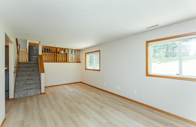 816 Bristol Ln NE, Rochester, MN 55906 - unfurnished living room featuring light wood-style flooring and stairs