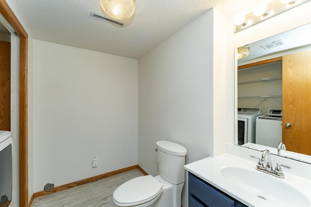 816 Bristol Ln NE, Rochester, MN 55906 - bathroom with washer and dryer, vanity, wood finished floors, and a textured ceiling