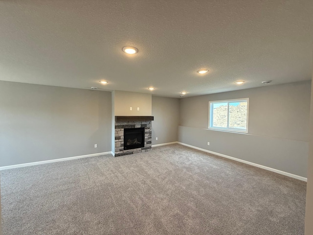 2883 Ivory Ave NE, Saint Michael, MN 55376 - unfurnished living room featuring carpet, a stone fireplace, a textured ceiling, and recessed lighting