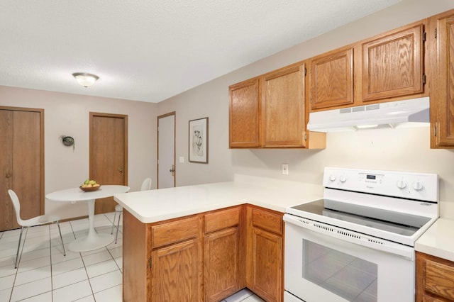 5960 Fernwood St, Shoreview, MN 55126 - kitchen with white electric range oven, under cabinet range hood, a peninsula, light countertops, and light tile patterned flooring