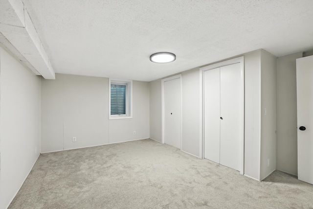 188 Cleveland Ave S, Saint Paul, MN 55105 - unfurnished bedroom with a textured ceiling, carpet flooring, and two closets