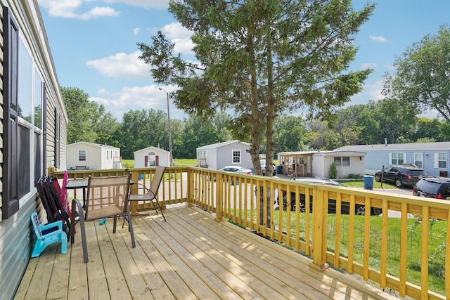 217 Mayfair Rd, Vadnais Heights, MN 55127 - deck featuring a residential view, a storage unit, a yard, and view of wooded area
