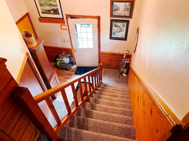 5019/5021 Ojibwa Rd, Brainerd, MN 56401 - stairway featuring a wainscoted wall, wooden walls, and carpet flooring