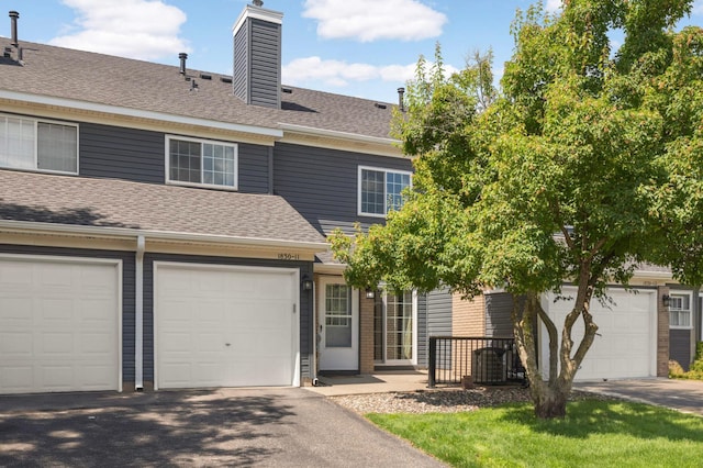 1830 Donegal Dr Unit 11, Woodbury, MN 55125 - multi unit property with a shingled roof, a chimney, driveway, and a garage
