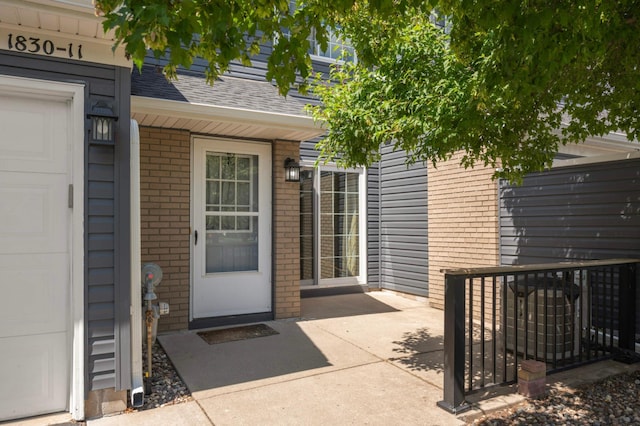 1830 Donegal Dr Unit 11, Woodbury, MN 55125 - property entrance with brick siding and roof with shingles