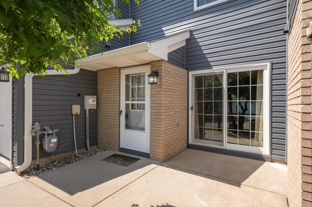 1830 Donegal Dr Unit 11, Woodbury, MN 55125 - doorway to property featuring brick siding and a patio area