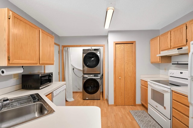 1830 Donegal Dr Unit 11, Woodbury, MN 55125 - kitchen featuring white appliances, stacked washer / drying machine, under cabinet range hood, light wood-type flooring, and light countertops
