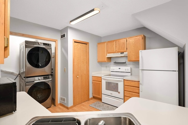 1830 Donegal Dr Unit 11, Woodbury, MN 55125 - kitchen with white appliances, estacked washer and dryer, under cabinet range hood, light countertops, and light wood-style floors