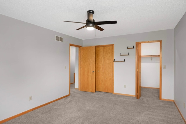 1830 Donegal Dr Unit 11, Woodbury, MN 55125 - unfurnished bedroom with light carpet, ceiling fan, a closet, and a textured ceiling
