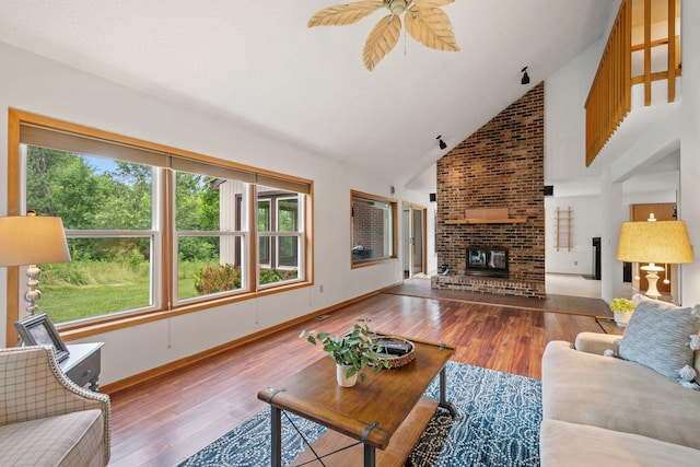 20170 Oxboro Ln N, Scandia, MN 55047 - living room featuring wood finished floors, ceiling fan, a brick fireplace, and high vaulted ceiling