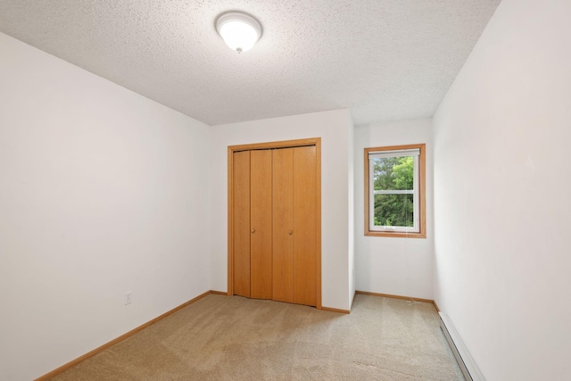 20170 Oxboro Ln N, Scandia, MN 55047 - unfurnished bedroom featuring light carpet, a textured ceiling, a closet, and a baseboard radiator