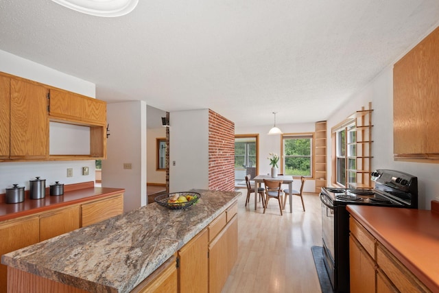 20170 Oxboro Ln N, Scandia, MN 55047 - kitchen featuring electric range, light wood-style flooring, a center island, a textured ceiling, and hanging light fixtures